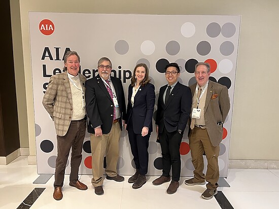 AIA leadership summit group photo showcasing diverse professionals in modern architectural setting.