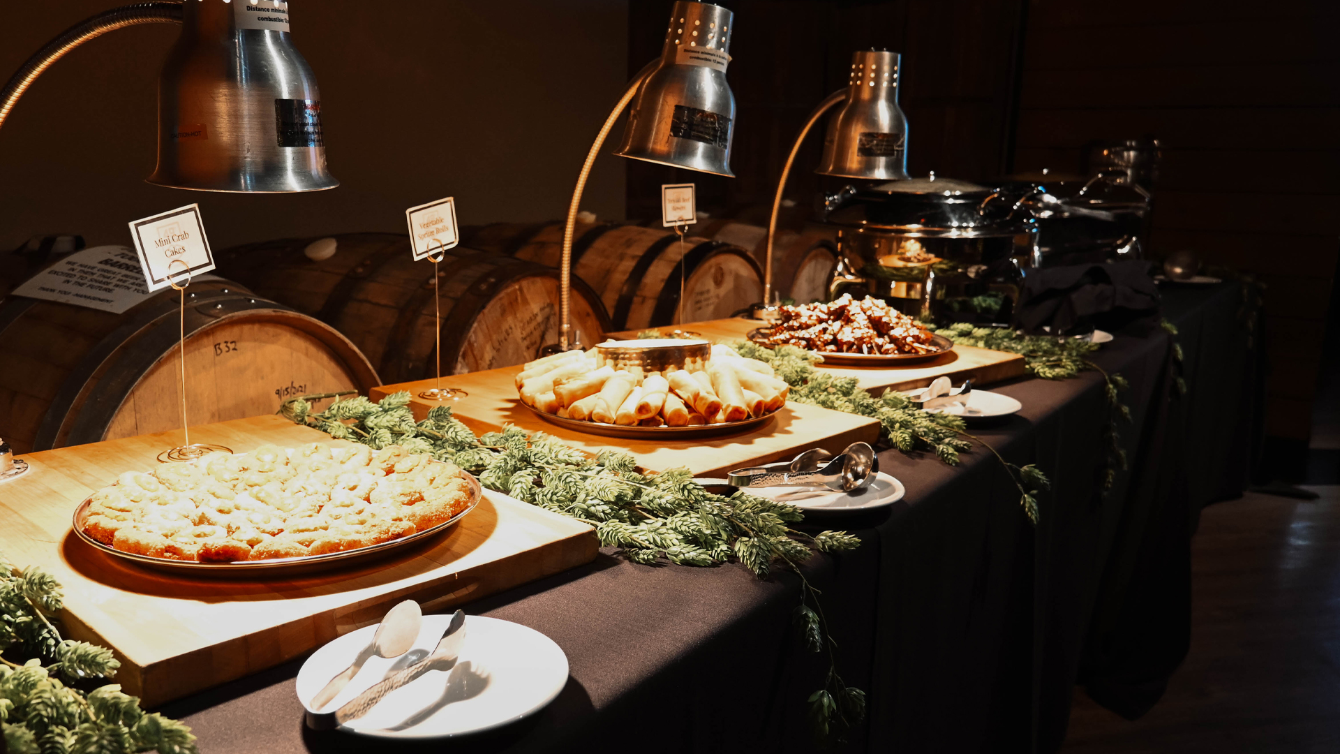 Elegant buffet display featuring crab cakes, spring rolls, and decadent desserts in a rustic setting.