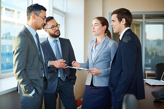 Professionals collaborate in a bright office discussing business strategies and solutions.