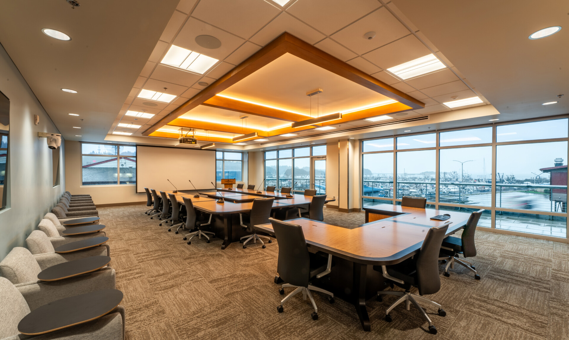 Modern conference room with marina view, ergonomic furniture, and advanced virtual conferencing setup.