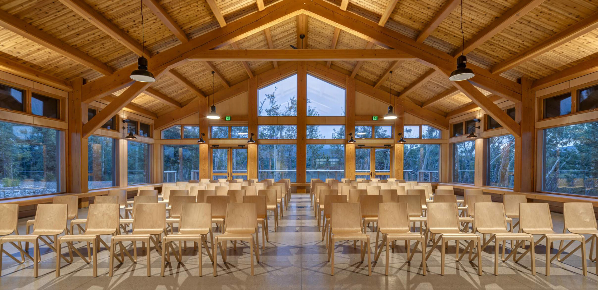 Spacious event gathering space with wood beams, large windows, and natural light for workshops.