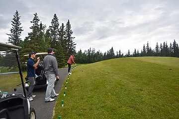 Friends enjoying a serene golf game on a lush course under soft, cloudy skies.
