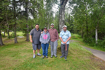 Friends enjoying a day of golf in a scenic park with lush greenery.