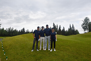 Group of four friends smiling on a scenic golf course, ready for a day of golf.